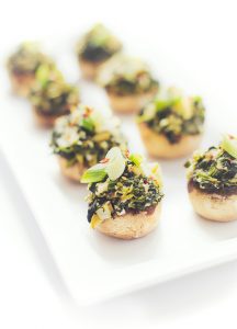 Host a beautiful, simple cocktail party with these Simple and Delicious Holiday Recipes and Tips | Spinach and Artichoke Stuffed Mushrooms