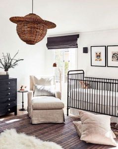 A black crib and dresser really pop in this white and cream nursery space