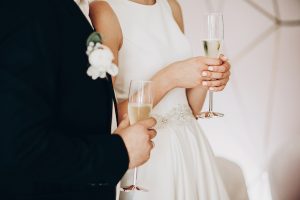 Bride and groom holding champagne glasses giving toast