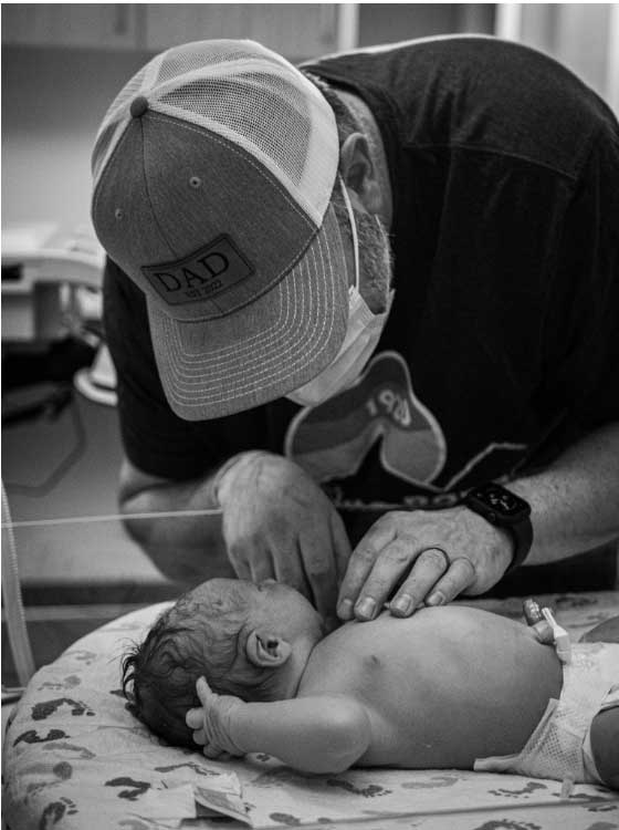 dad touching newborn