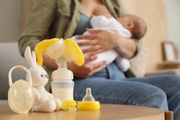 Breast pump with baby pacifier and toy on table in room