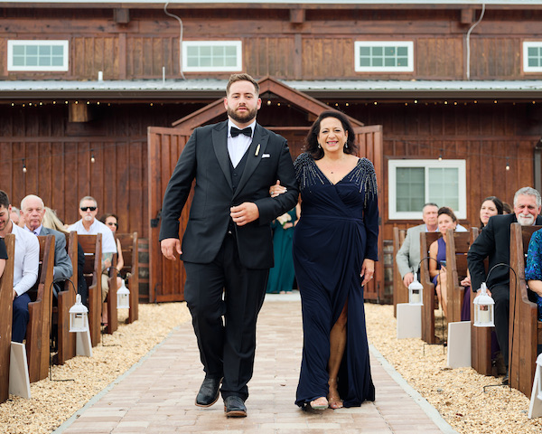 groom and mom walking down the aisle